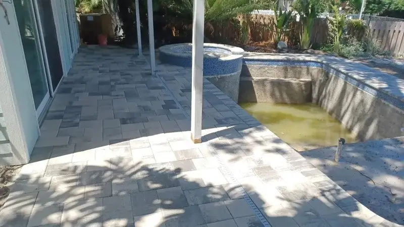 Side angle of concrete pool shell and raised spa under construction next to a canal