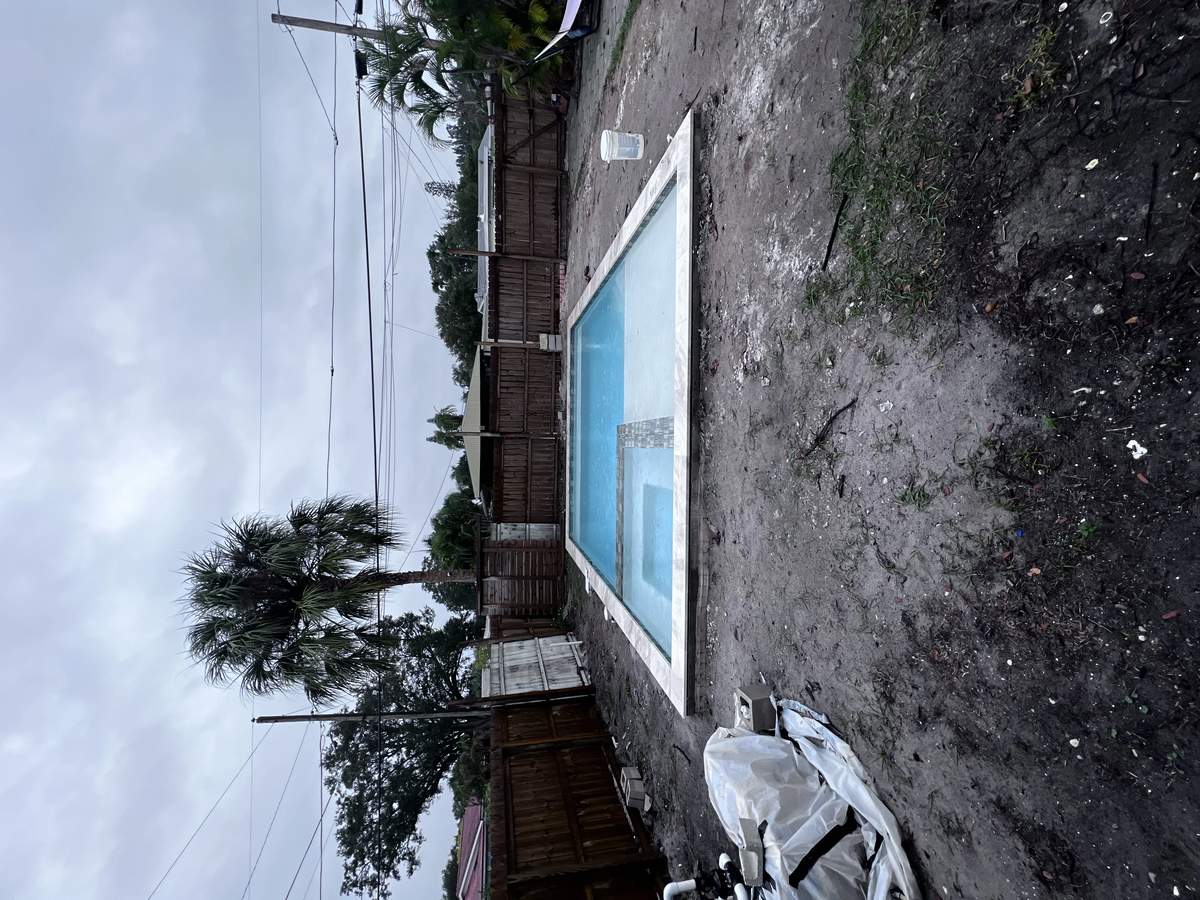 Under-construction rectangular pool with new water filling and dirt deck area