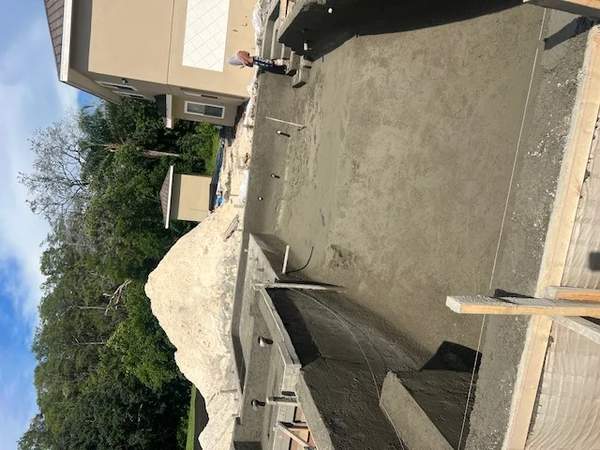 Angle shot of a freshly poured concrete pool vessel and wood framing braces