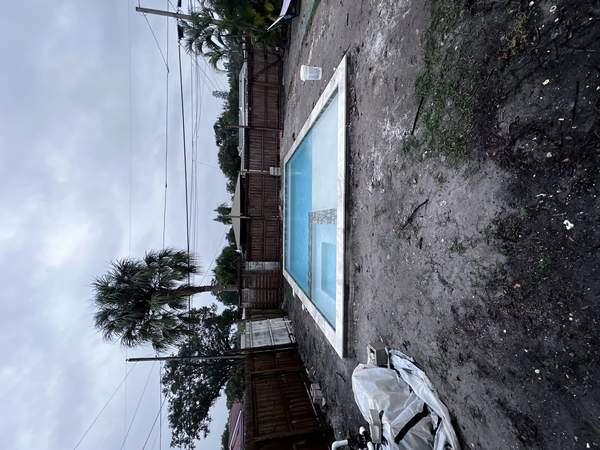 Under-construction rectangular pool with new water filling and dirt deck area