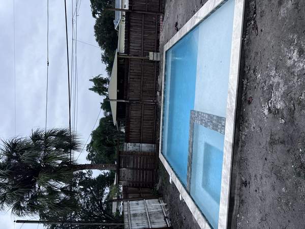 Close-up of water-filled custom pool shell and stone coping during active build