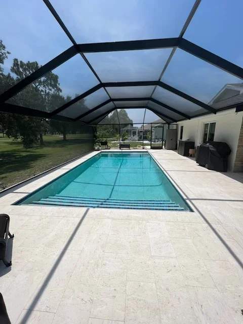 Screen-enclosed rectangular pool showing a full-width steps entry layout