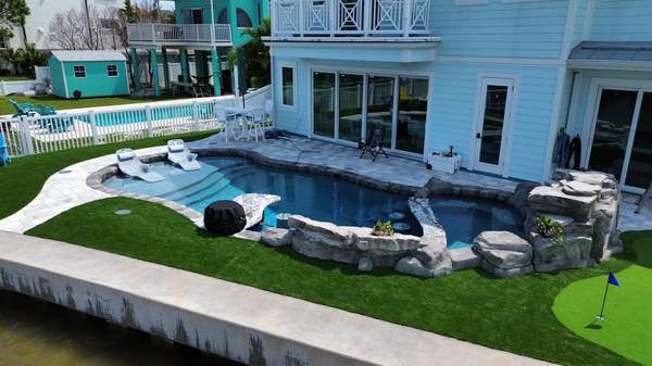 Drone photograph of a coastal pool showing custom swim-up bar and putting green